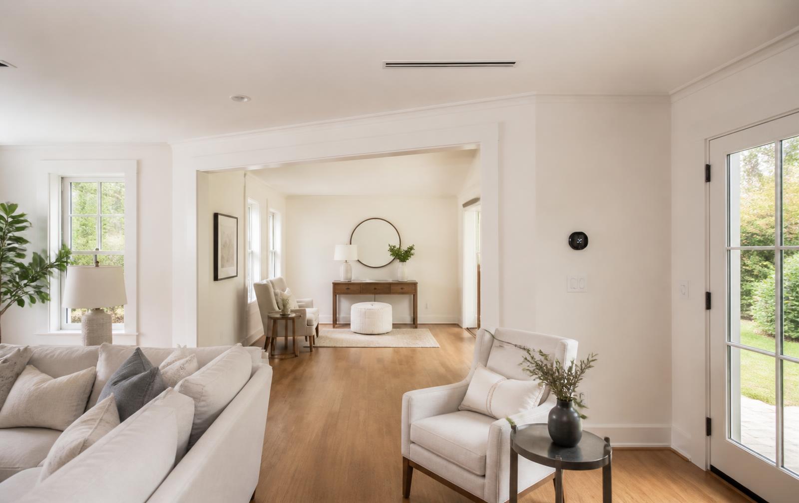 Finished New England living space with discreet ceiling supply vent, a simple wall thermostat, oak floors and natural light